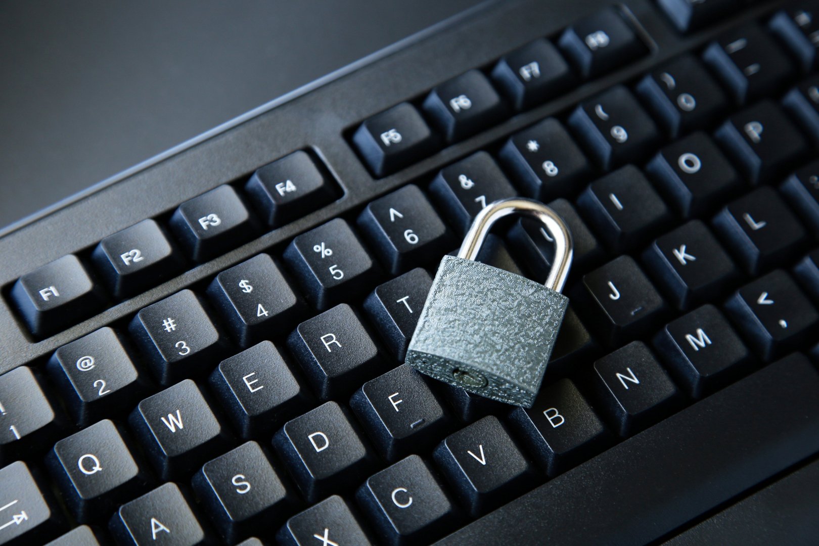 high-angle-shot-lock-black-computer-keyboard-black-surface.jpg